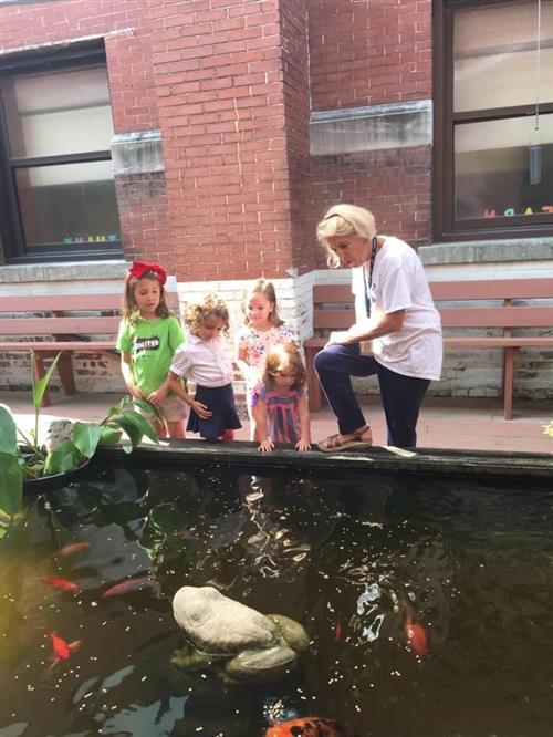 Ms. Phillips with students by the pond 
